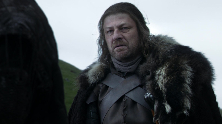Ned Stark wearing fur cloak during tense moment in Game of Thrones season 1