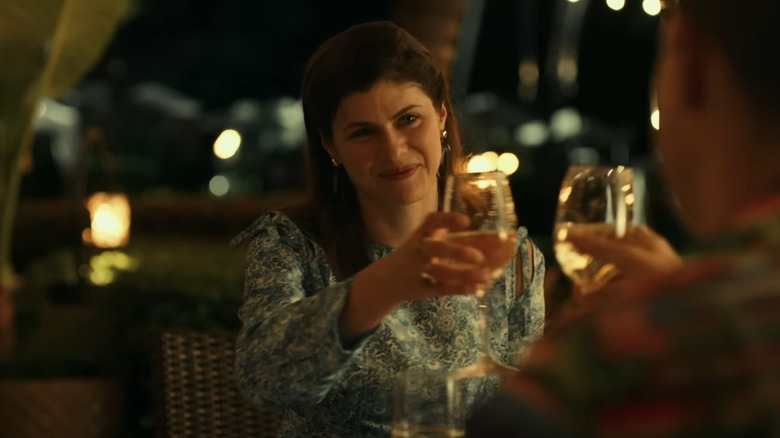 Rachel Patton raising wine glass during dinner scene in The White Lotus season 1