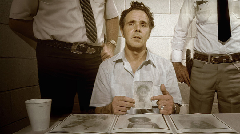 Henry Lee Lucas holding up photo at the police station
