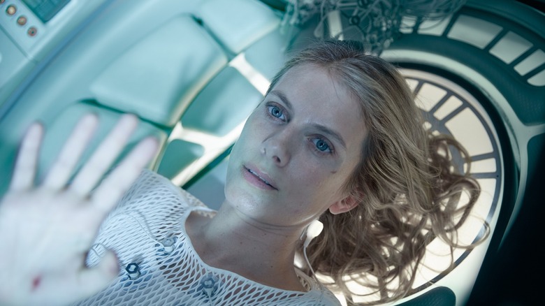 Liz holdhing her hands up while strapped to a machine