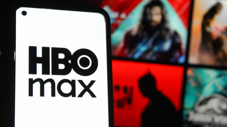 HBO Max logo on phone screen with streaming interface in background
