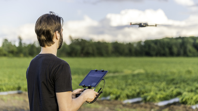 A person flying a drone with a tablet controller.