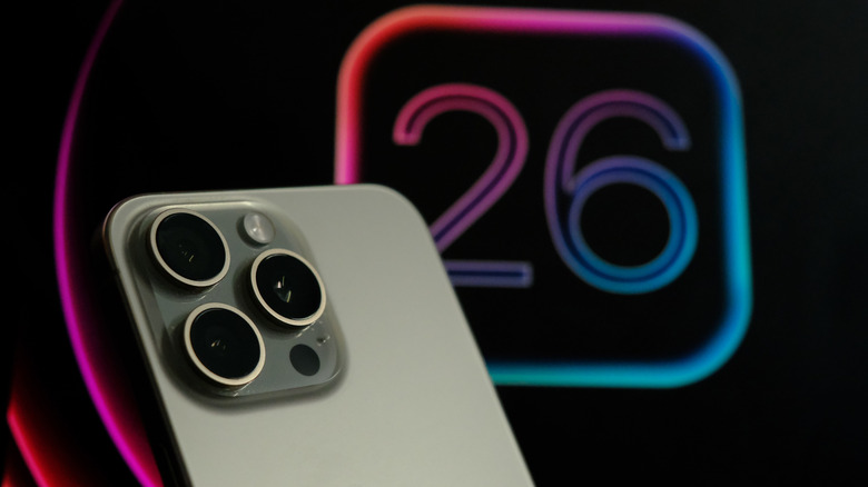 iOS 26 logo in the background with a silver iPhone 16 Pro in the foreground.