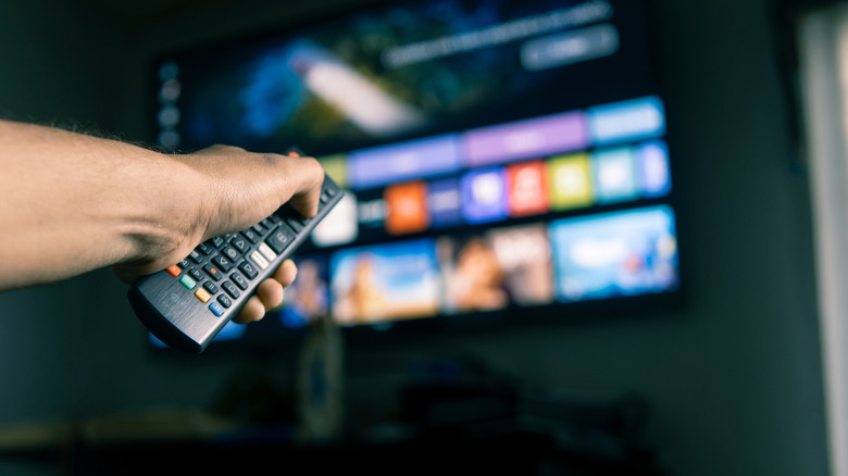 Person using remote to navigate Netflix on smart TV