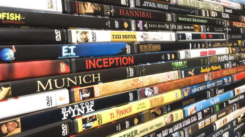 A densely-stacked wall of DVD movies featuring numerous classic titles.