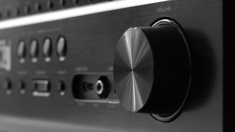 A front view of a black AV receiver with a large volume knob.