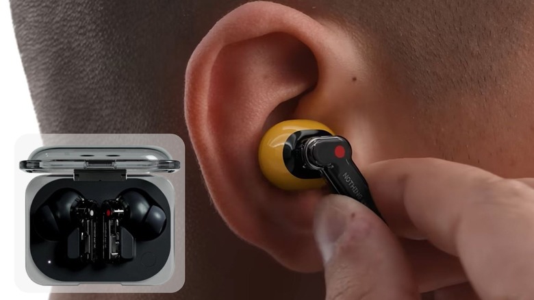 Nothing Ear (a) headphones being placed into ear.