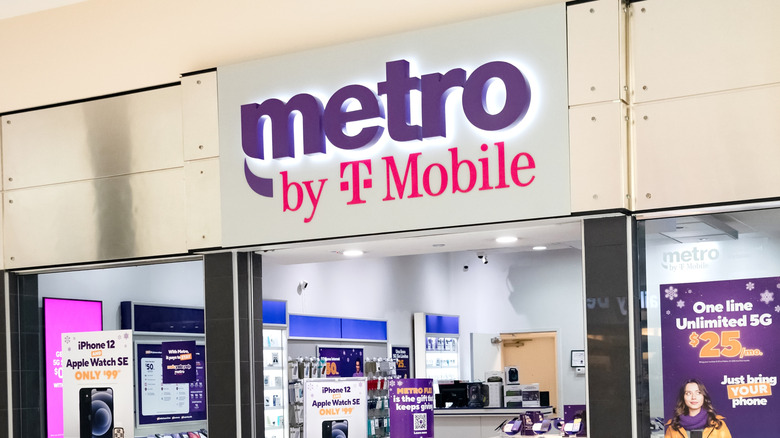 A Metro by T-Mobile storefront with a promotional phone plan signs in the window.
