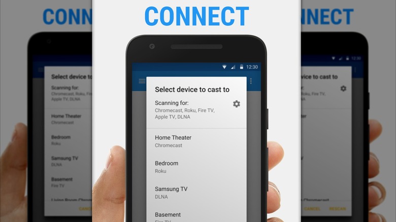 A promotional image from the Google Play Store for the Web Video Cast app, the image shows a hand holding a smartphone, showing a list of devices that can have cast media sent to it