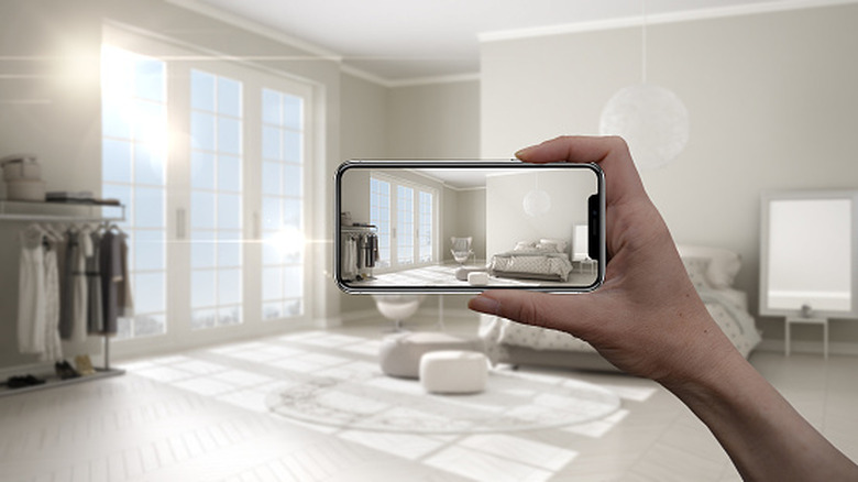 A person clicking an image of a room with their phone
