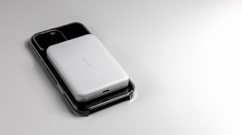 An iPhone being charged by an Anker MagSafe power bank