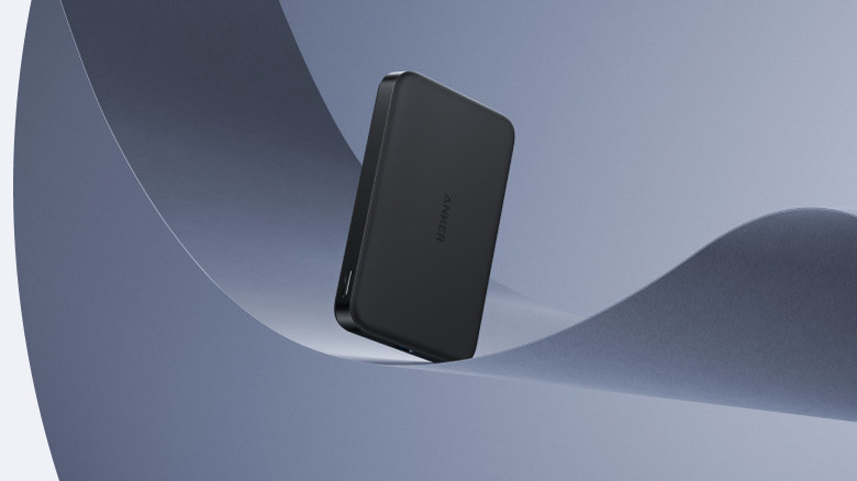 Anker MagGo Power Bank standing upright against a minimalist gray background with curved shapes.