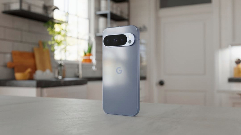 Google Pixel 10 standing upright on a kitchen counter with the rear camera bar visible.