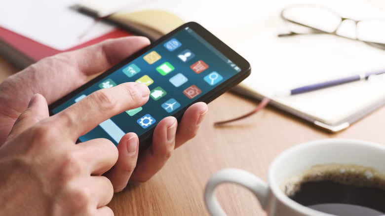 Hand tapping on phone showing minimalist apps
