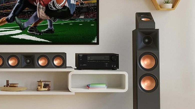 The Onkyo TX-NR6100 set up on top of an entertainment center in a modern living room, powering a set of speakers.
