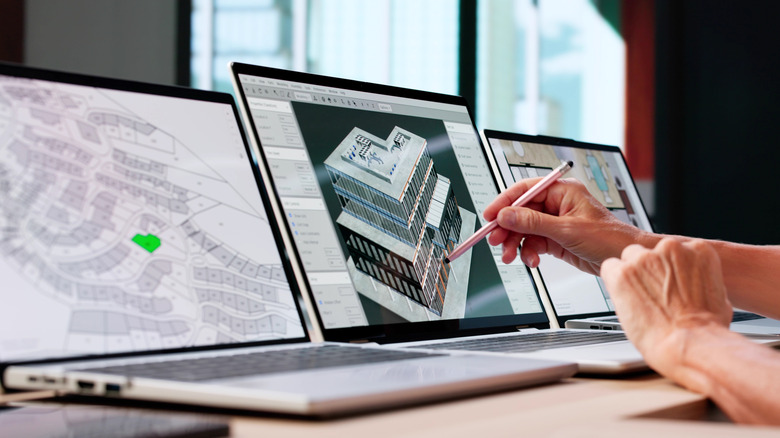 Person using a stylus to interact with architectural design on a laptop screen