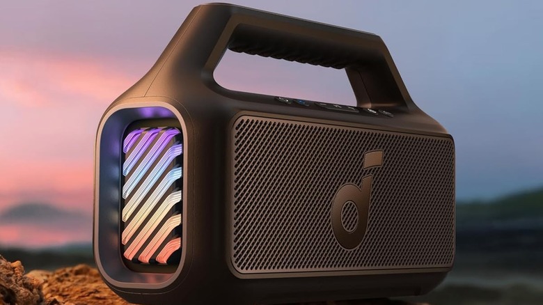 The Anker Soundcore Boom 2 sitting on a rock in an outdoor setting.