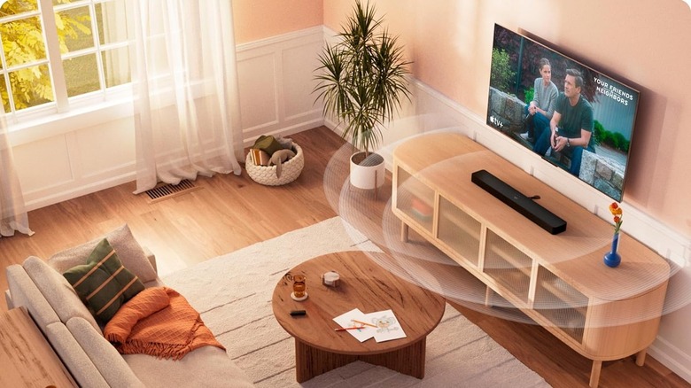 The Amazon Fire TV Soundbar Plus set up in a modern living room. Sound waves emanating from it demonstrate its immersive capabilities.