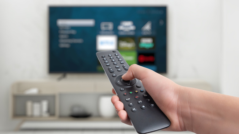 hand pointing remote at smart television