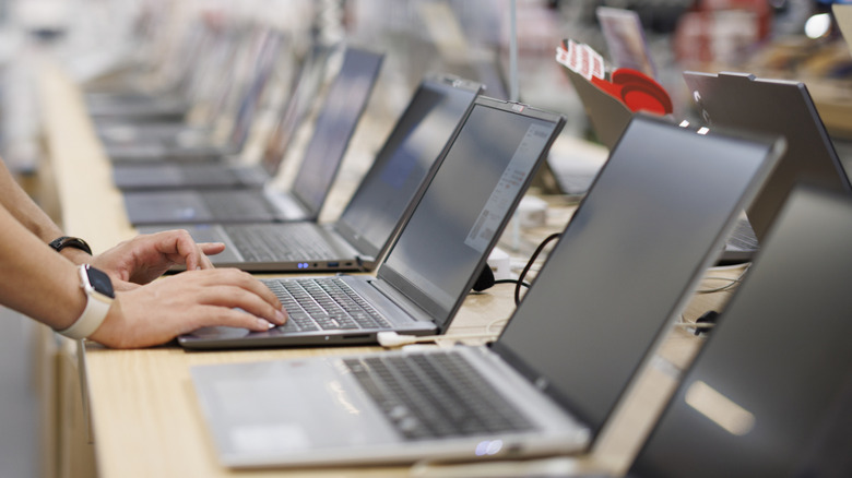 A person using a laptop in an electronics store