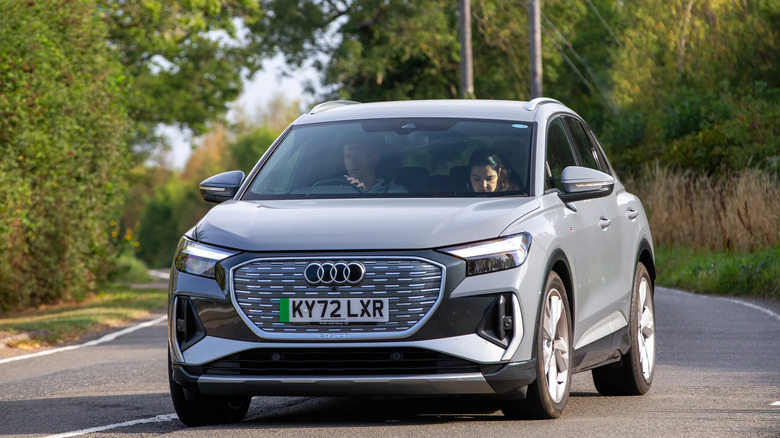 The 2025 Audi Q4 E-Tron in gray being driven on a road