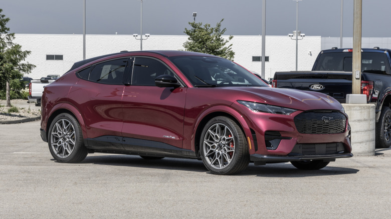 A Maroon Ford Mustang Mach-E is parked in dealership