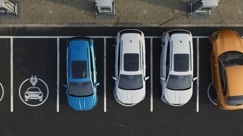 Four electric cars charge in a parking lot