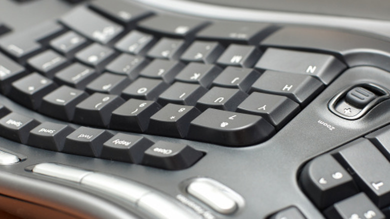 A closeup of a black ergonomic keyboard showing its split style and wavy design choice