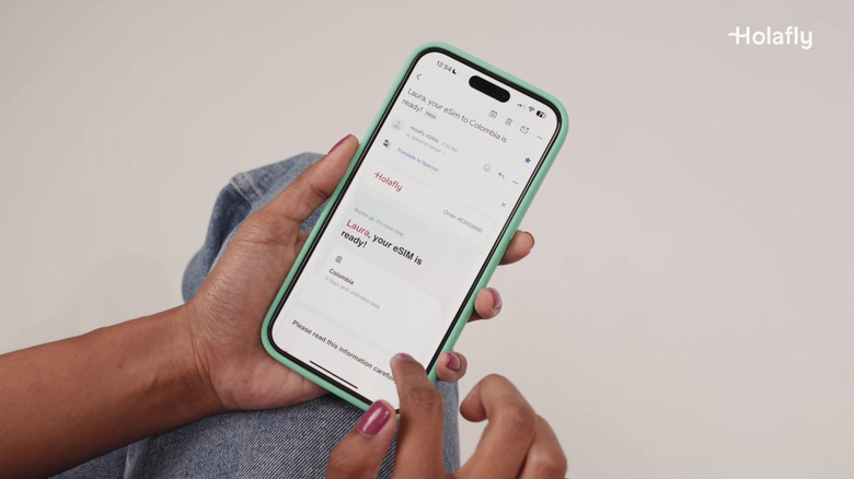 Person setting up a Holafly eSIM on a smartphone screen.