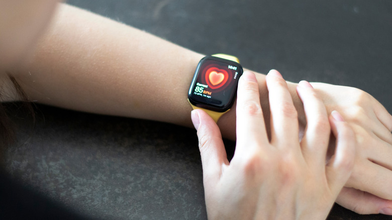 Woman's hand with Apple Watch Series 8 measuring heart rate.