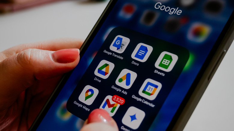 Google app folder open on a smartphone screen with Drive, Gmail, Docs, Sheets, and other app icons.