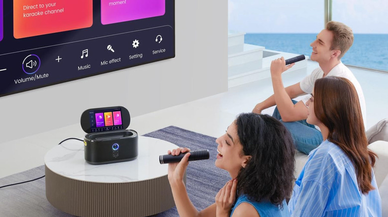 Singers gathered around a TV and the Ikarao Shell S1 karaoke machine
