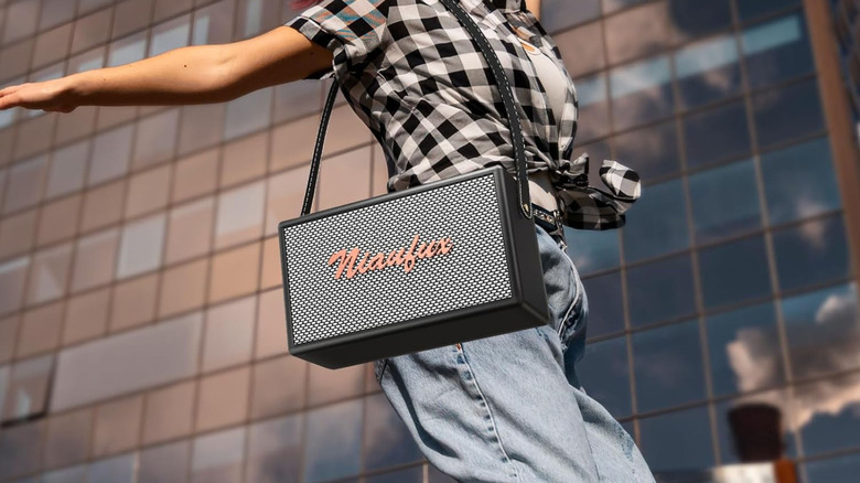 A person with a Niaufux S16 karaoke machine slung over one shoulder