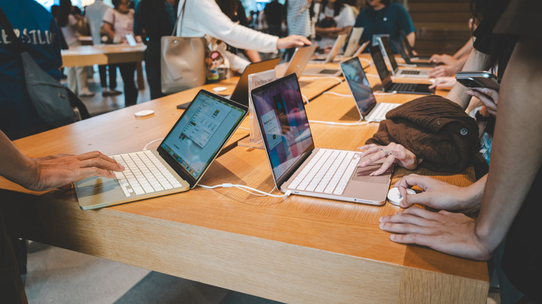 People using MacaBook Neo laptops at an Apple Store