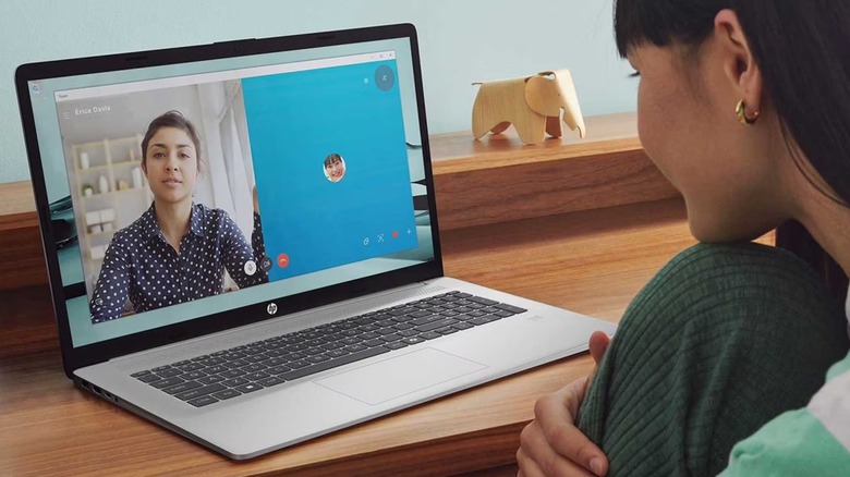 A woman using a HP 17.3-inch FHD Windows 11 Laptop as it sits on her desk