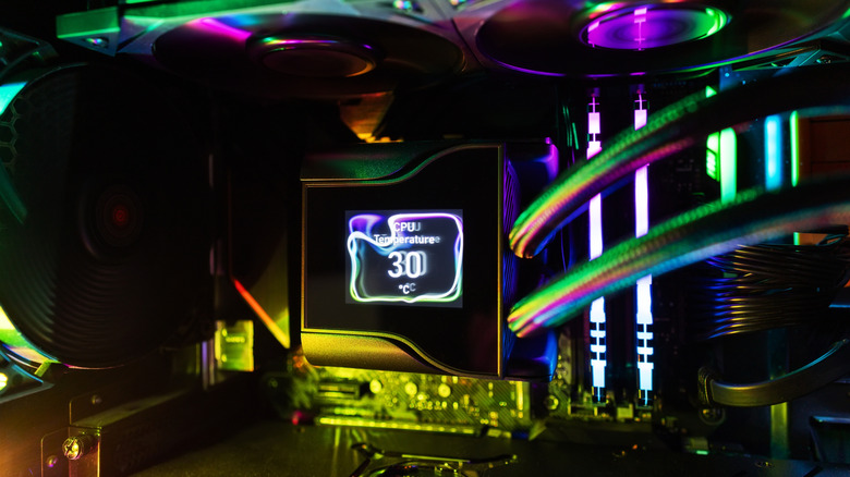 RGB-lit gaming PC interior with an AIO liquid cooler showing CPU temperature on its LCD pump display.