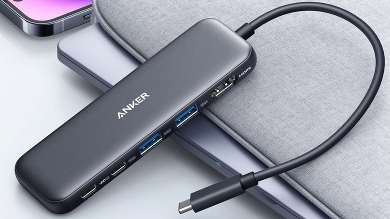 Anker 332 USB-C Hub resting on a MacBook and laptop sleeve