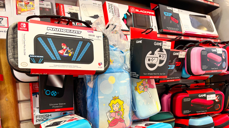 switch 2 accessories on a shelf at a store, includes a wheel controller accessory and a few different carrying case options