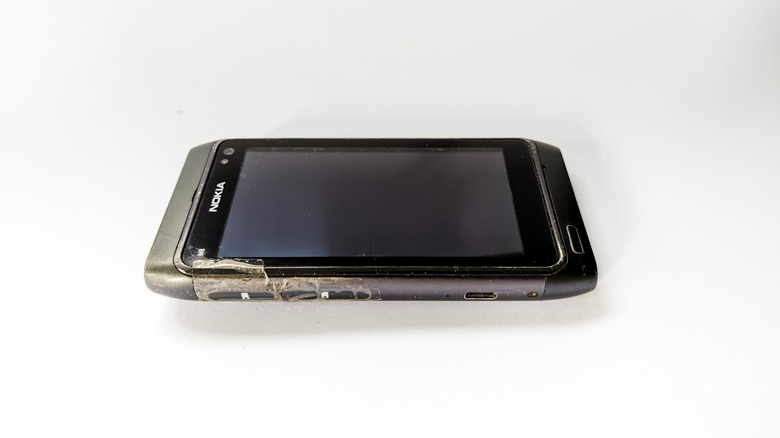 Nokia N8 smartphone shown on a white background with visible wear.