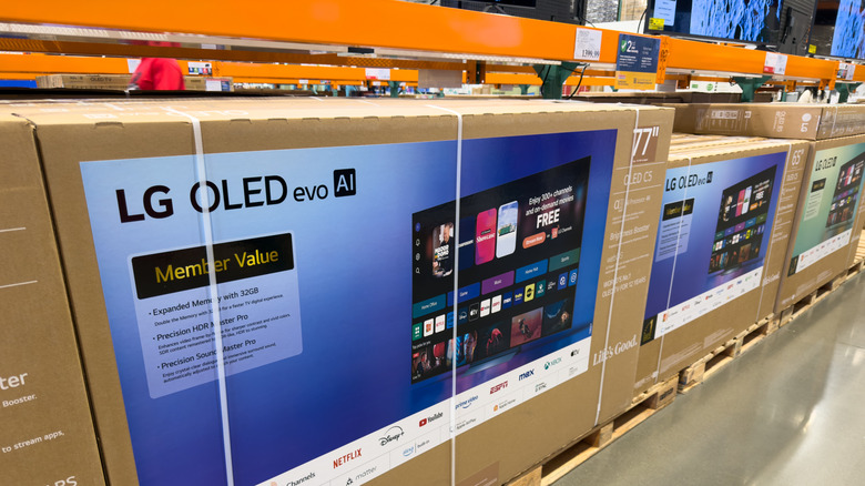The LG 77-inch C5 Series in its box on a palette, placed next to other LG TV palettes.