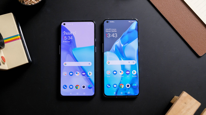 The OnePlus 9 and OnePlus 9 Pro placed side by side on a black tabletop.