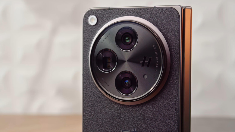 Close-up of the OnePlus Open with its black leather back and circular Hasselblad camera module.