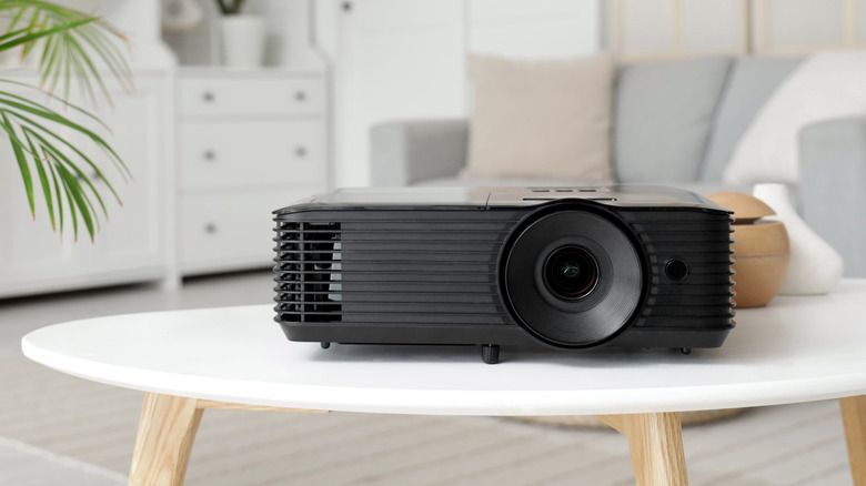 A black projector on a table in a room