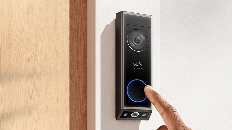 Close-up of a person ringing the Eufy Security Video Doorbell E340 mounted on a wall