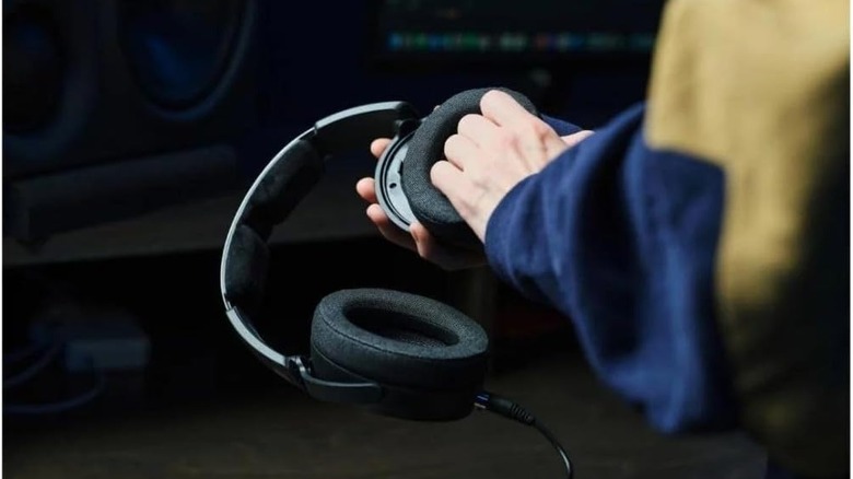 A person attaching ear pads to the Sennheiser HD 490 PRO Wired Headphones.