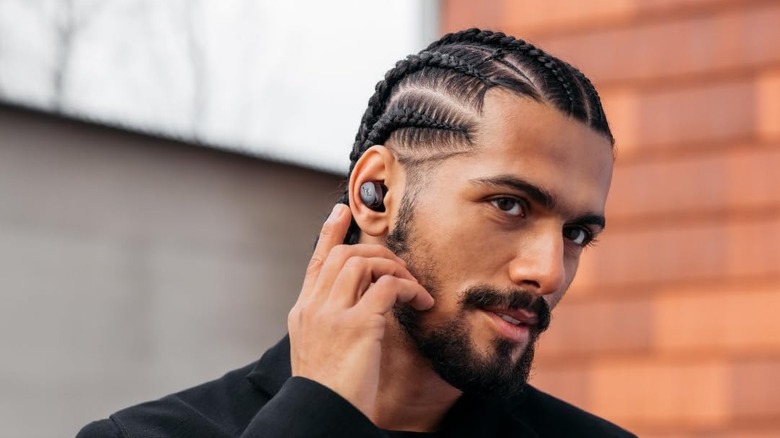A man wearing the Sennheiser Momentum 4 Wireless Earbuds.
