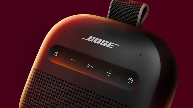 A closeup of the Bose SoundLink Micro 2 as it sits against a dark red backdrop