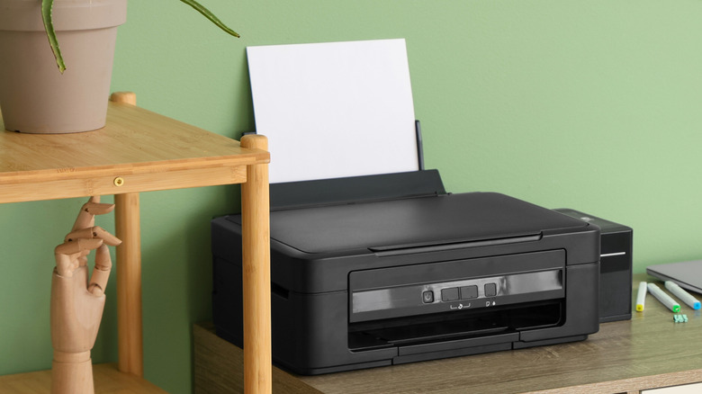 A black printer on a study table in a home