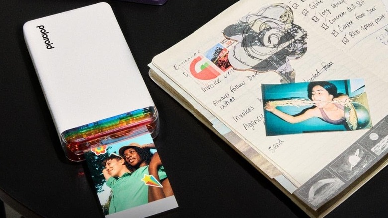 Polaroid Hi-Print 2x3 Generation 2 on a black surface with a notebook on the side