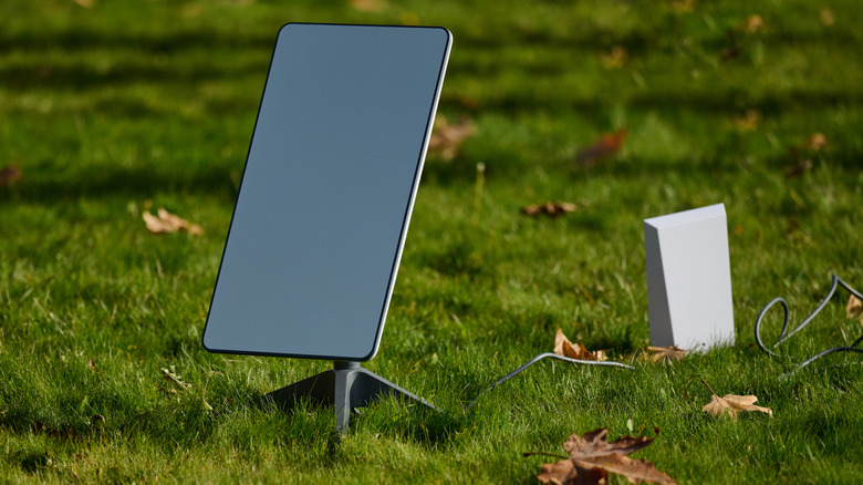 A satellite receiver system set up on green grass.
